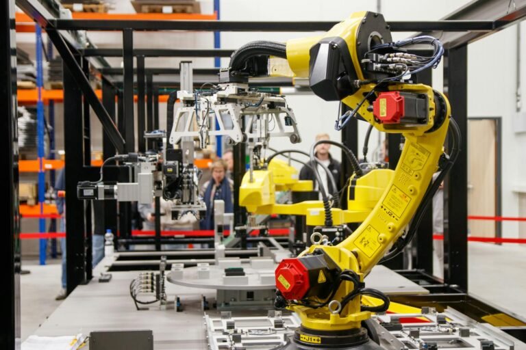 Braço robótico industrial amarelo representando automação de processos repetitivos com Bash scripts para produtividade