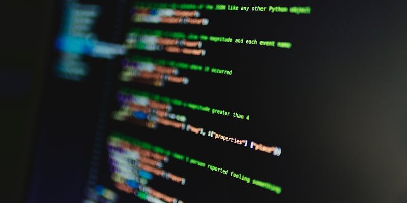 Linhas de código coloridas em tela representando programação de automações