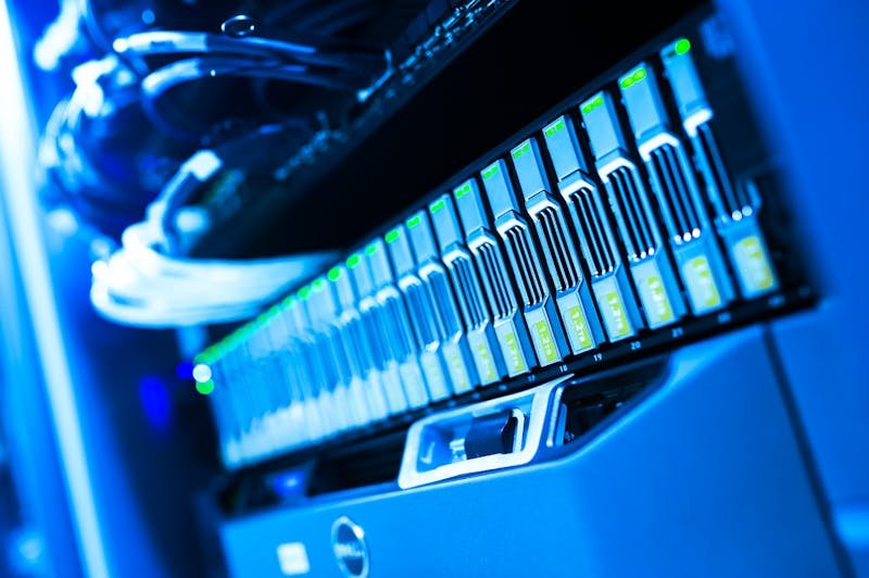 Rack de servidores iluminados em data center representando infraestrutura de segurança digital e monitoramento
