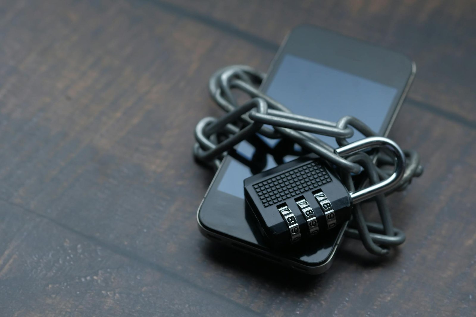 Smartphone envolto em corrente com cadeado simbolizando a proteção forte de senhas com password manager e 2FA
