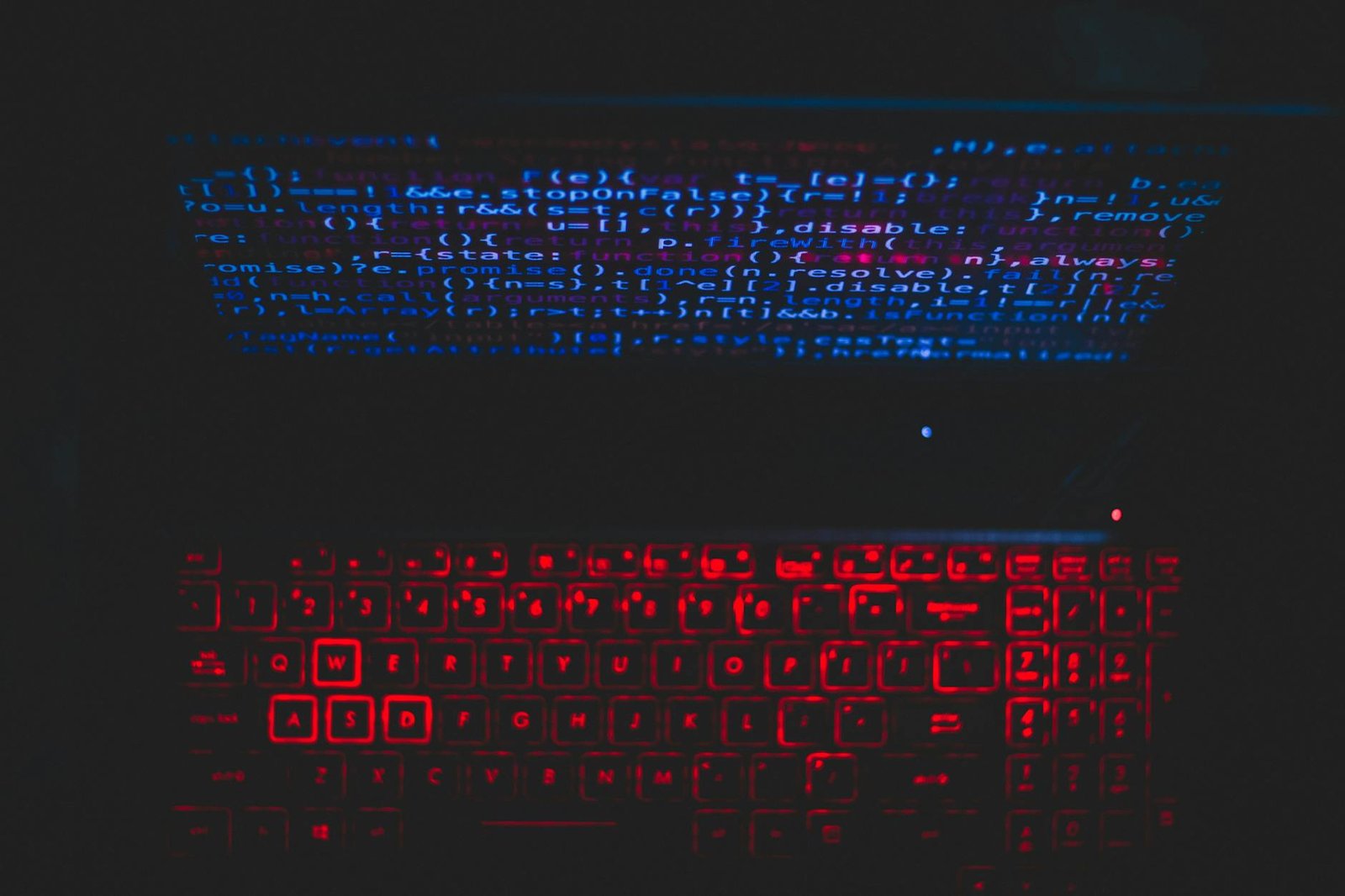 Teclado iluminado em vermelho com código em tela escura representando automação com scripts Bash no terminal