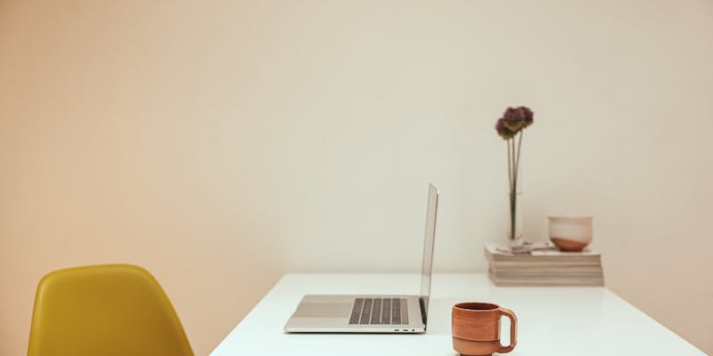 Workspace sereno com laptop e café simbolizando rotina produtiva automatizada