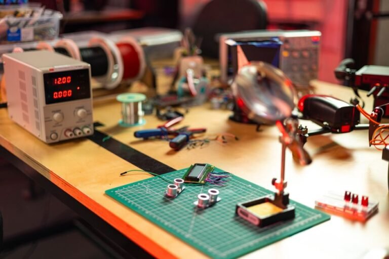Bancada eletrônica organizada com componentes, cabos e ferramentas para projetos maker e debug de circuitos