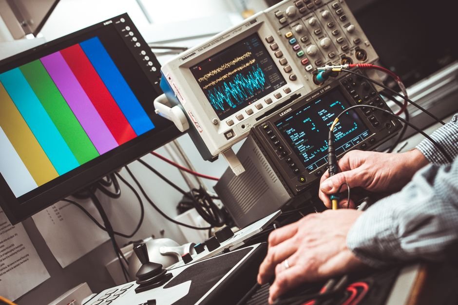 Osciloscópio e equipamentos de medição eletrônica com displays coloridos em bancada de laboratório