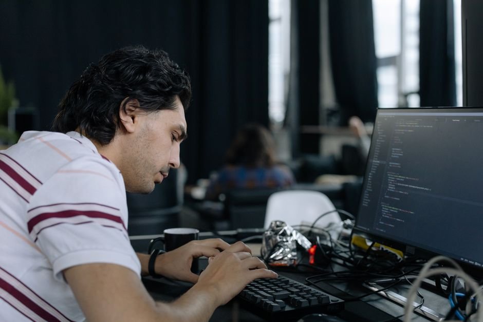 Programador digitando intensamente em estado de concentração profunda