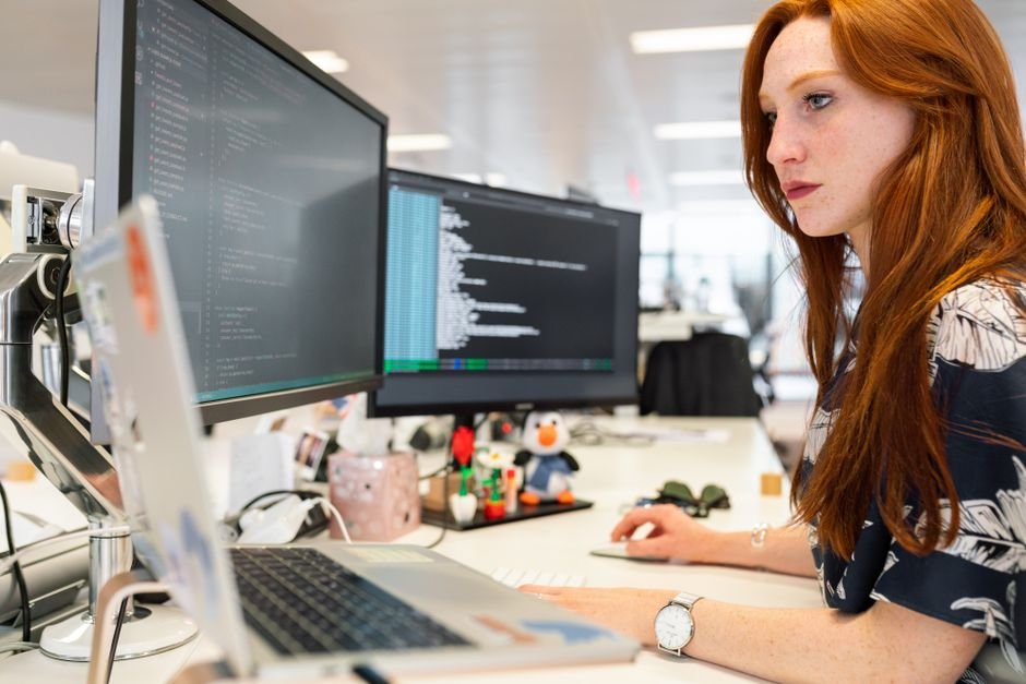 Engenheira de software focada trabalhando com monitores duplos em sessão de deep work
