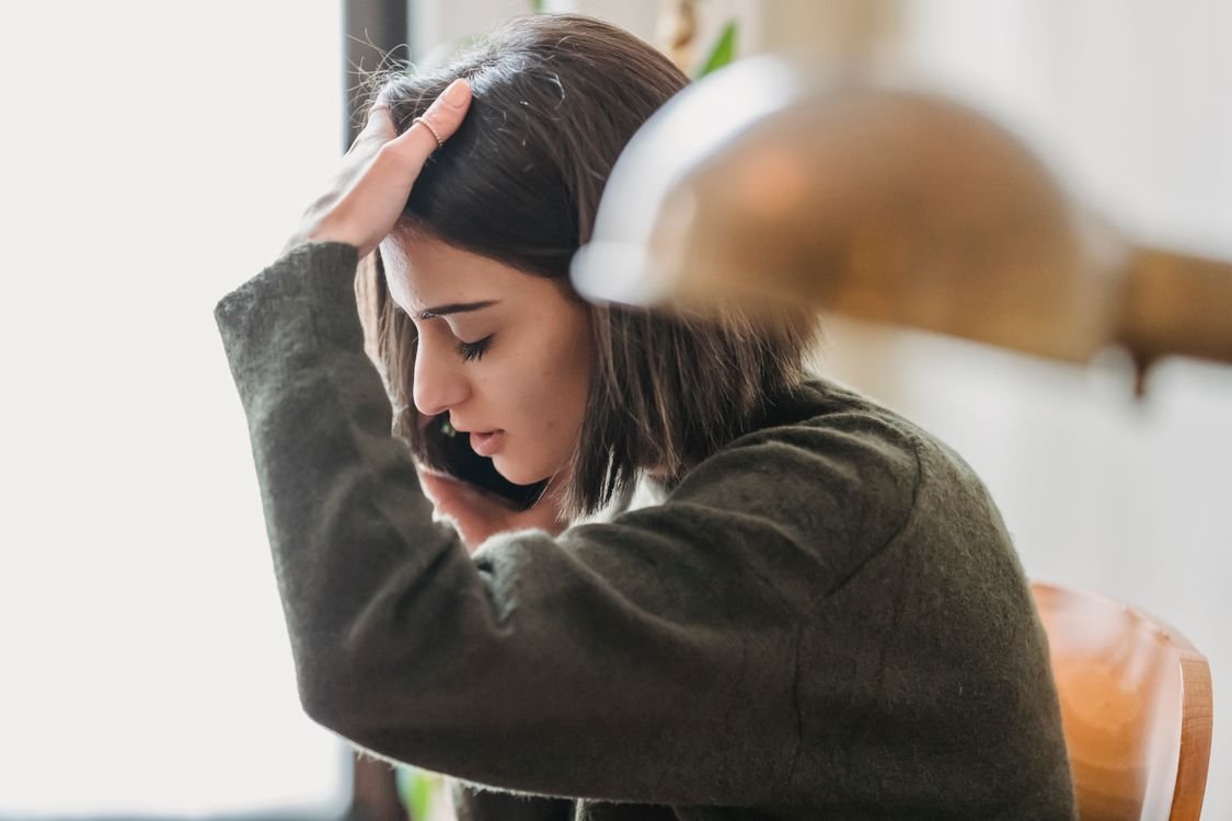 Mulher estressada ao telefone após receber ligação suspeita