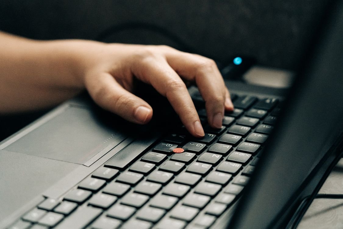 Pessoa digitando no laptop — transcrever áudio economiza horas de trabalho manual