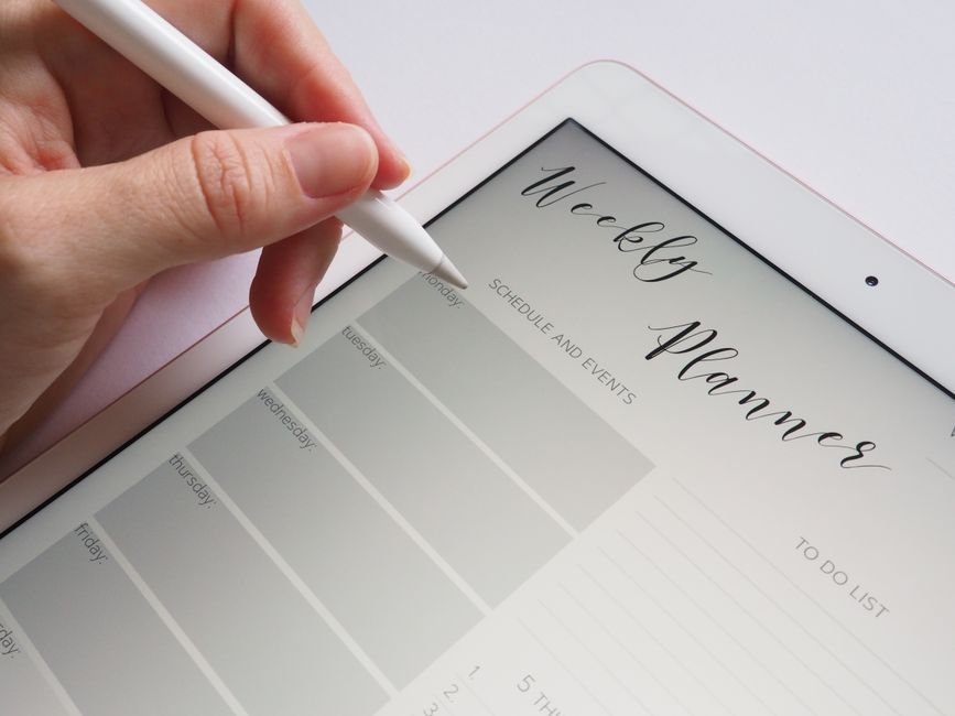 Tablet com planner digital e stylus em mesa de trabalho organizada